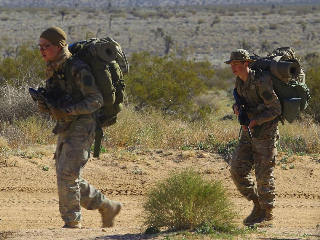 Two explorers rucking with full packs through the Mojave Desert